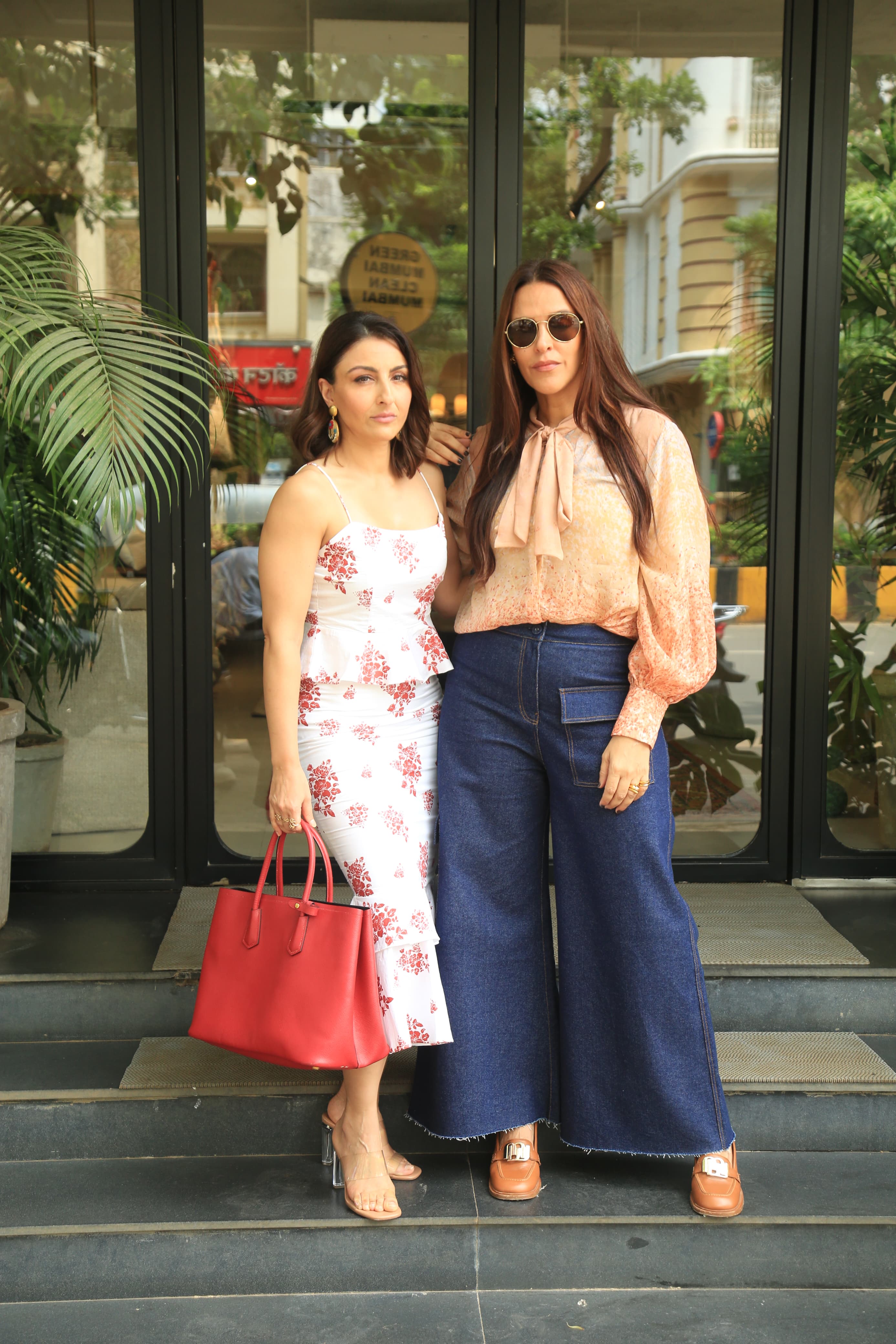 Soha Ali Khan was spotted posing with Neha Dhupia in the city as they enjoyed a small outing. Soha looked beautiful in white adding a pop of colour with her red handbag, Neha kept is casual in a white legged denim and a top.